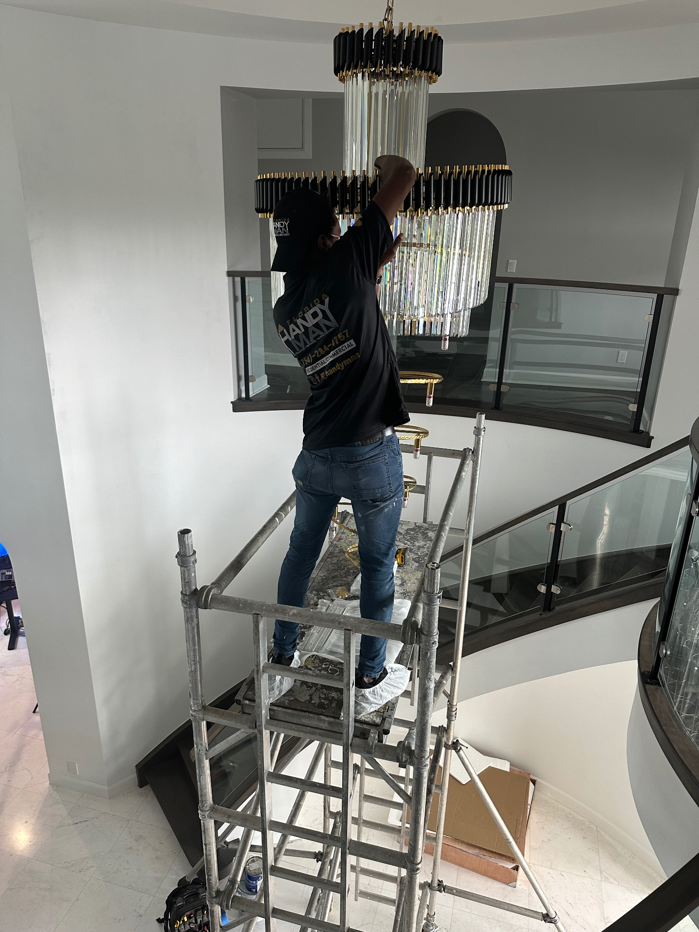 Professional handyman installing chandelier