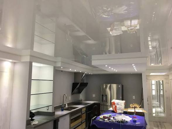 Completed glossy stretch ceiling installation in Hialeah kitchen with integrated LED lighting